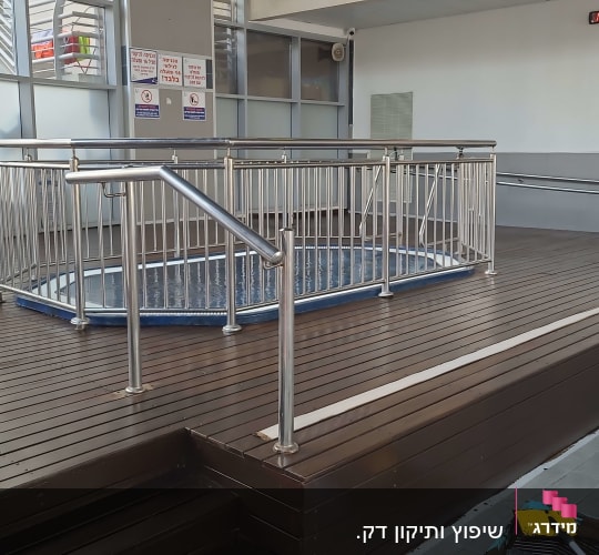 רצפת עץ עם מעקה מתכת סביב בריכה קטנה
